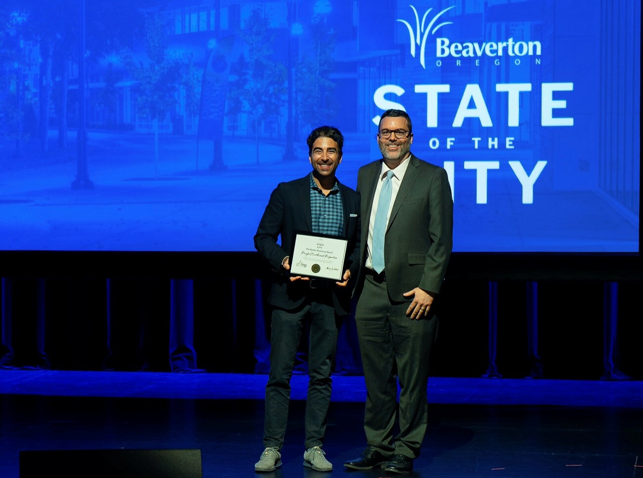 Beaverton City Council President John Dugger presents Evan Bernstein and the Pacific NW Properties team with the 2026 “Better Business Award.”